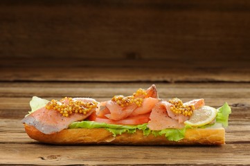 Sandwich with red fish, tomatoes and mustard