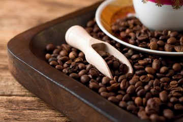 Fototapeta premium Coffee grains on tray from dark wood