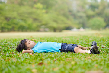 Boy lay on the green lawn