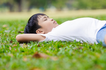 Boy lay on the green lawn