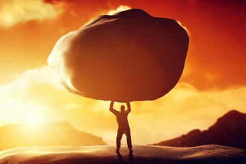 Man lifting a huge rock. Concept of strength, ballast, power