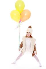 Little girl in hat and coat holding a balloons.
