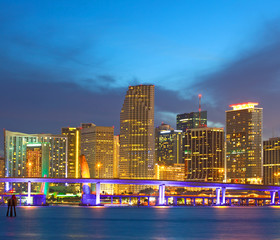 Obraz premium Miami Florida USA, sunset or sunrise over the city skyline of downtown business and residential illuminated buildings, with colorful clouds and reflections in the water of Biscayne Bay,
