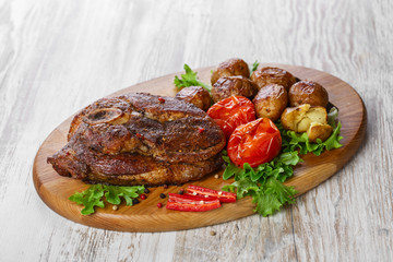 roasted pork shoulder on the bone with potatoes