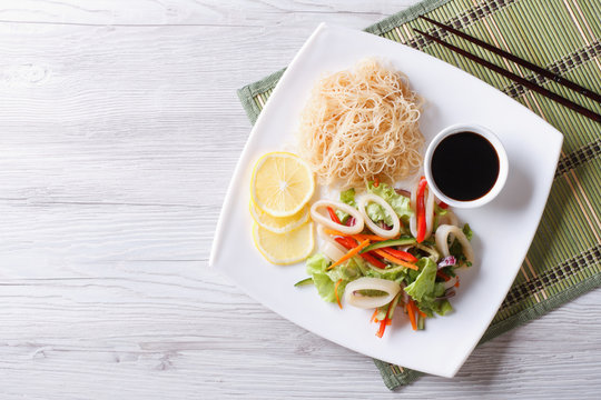 Rice noodles and vegetable salad with squid horizontal top view