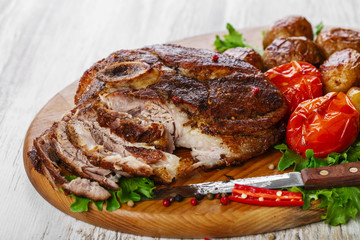 roasted pork shoulder on the bone with potatoes
