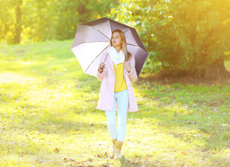 Petty sensual woman with umbrella in sunny autumn day