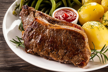 Beefsteaks, boiled potatoes and vegetables