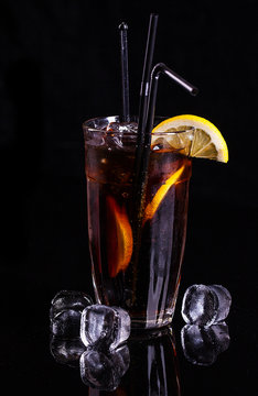 Glass of cola with ice and lemon.