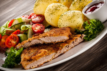 Fried pork chops, boiled potatoes and vegetable salad
