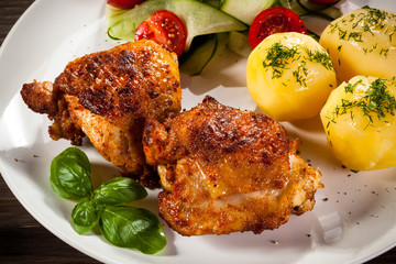 Barbecued chicken legs with boiled potatoes and vegetables