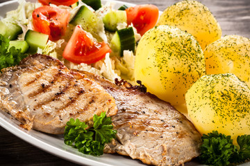 Grilled steaks, boiled potatoes and vegetable salad