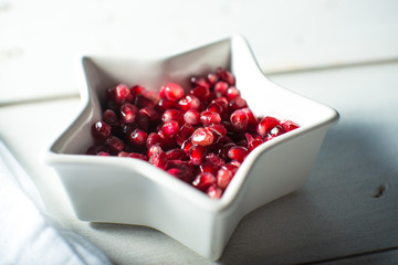 White bowl with fresh ripe pomegranite seeds
