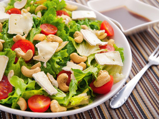 Green salad with brie, cashew and cherry tomatos