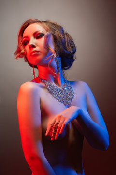 Portrait of pretty nude model advertises jewelry