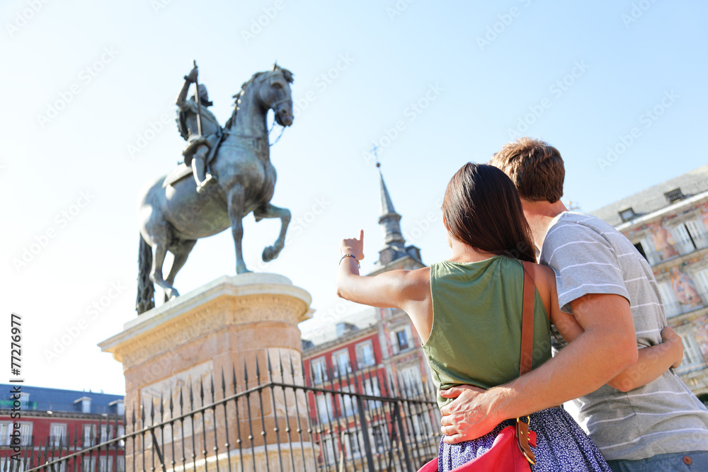 Wall mural madrid tourists on plaza mayor looking at statue