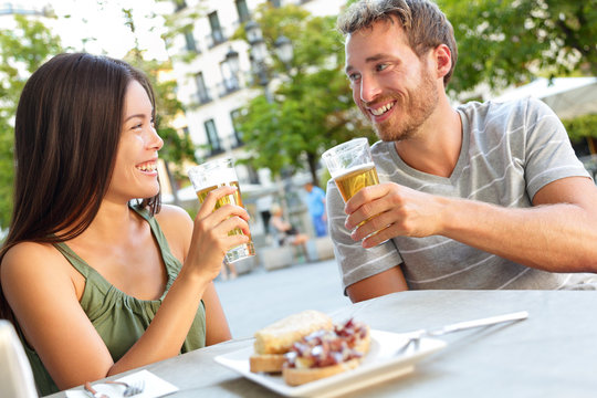 Couple eating tapas drinking beer in Madrid Spain