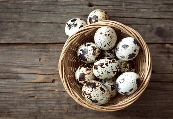 Tuinposter quail egg in a wooden bowl © emilijamanevska