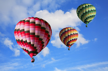 Three big multi-colored balloons in the blue sky