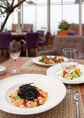 Black squid ink pasta with seafood on table