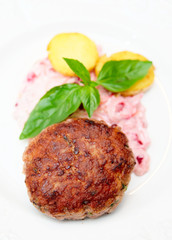 Beef patty cake with creamy sauce and potatoes
