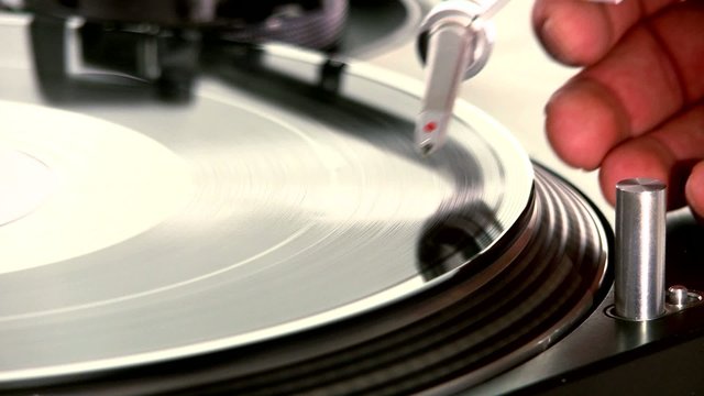 DJ Turntable. Dropping the needle on a spinning viny close-up