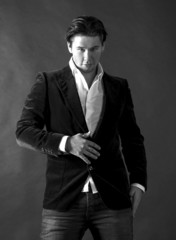 Elegant smiling young handsome man on a dark background