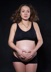 a pregnant woman  in different positions on the black background