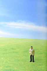 草原に佇むタキシードの男性