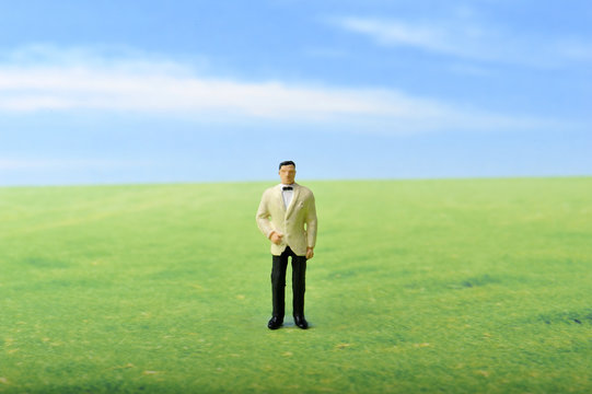 草原に佇むタキシードの男性