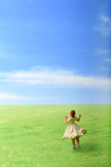 Naklejka na ściany i meble 草原でダンスしているスカートを履いた女性のミニチュア人形