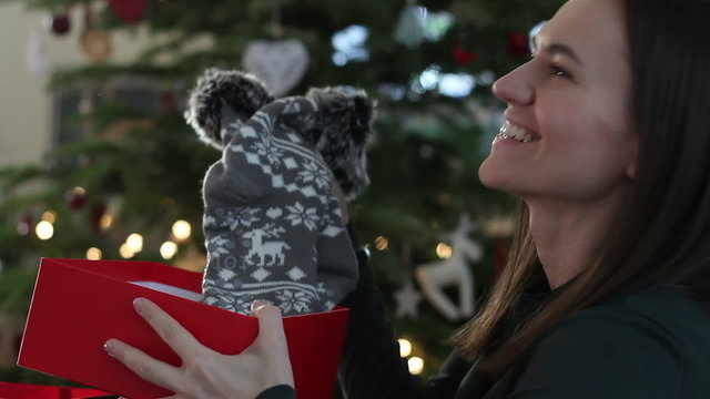 Happy surprised woman opening gift box at home