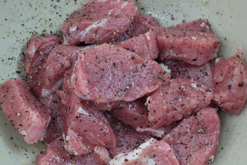 Raw pieces of pork sirloin seasoned and ready to cook.