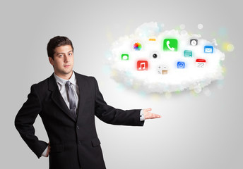 Young man presenting cloud with colorful app icons and symbols