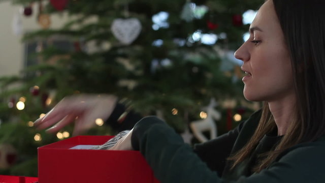 Young charming woman wraps gifts for Christmas