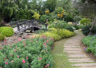 Keuken spatwand met foto landschap van bloementuinieren met pad en brug in de tuin © sutichak