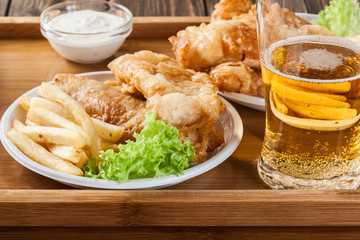 Fish and chips with tartar sauce on a tray