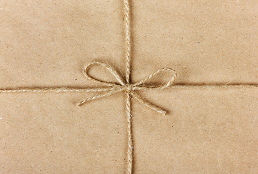 string or twine tied in a bow on kraft paper background