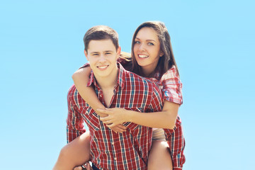 Summer happy young hipster couple having fun outdoors against th