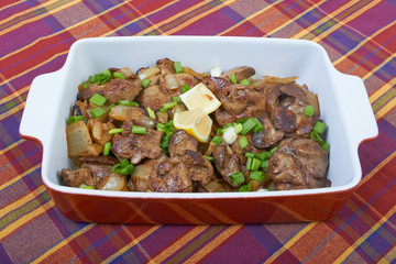 Fried chicken liver in a ceramic plate isolated on a checkered t