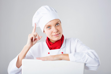 Smiling and cheerful female chef, cook or baker in uniform