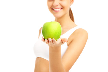 Fit woman giving green apple