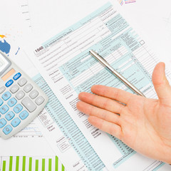Obraz premium US 1040 Tax Form, male hand and silver pen - studio shot