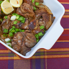 Fried chicken liver in a ceramic plate isolated on a checkered t