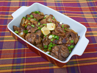 Fried chicken liver in a ceramic plate isolated on a checkered t