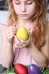 Fototapeta na wymiar Adolescent girl painting Easter eggs