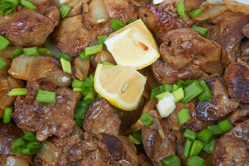 Fried chicken liver in a ceramic plate isolated on a checkered t
