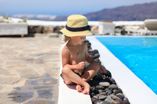 Adorable little girl near pool during greek vacation in