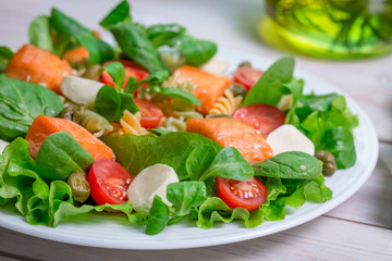 Closeup of salad with fresh vegetables and salmon