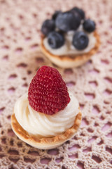 Sweet tartlets filled with cream and blueberry, raspberry and ma